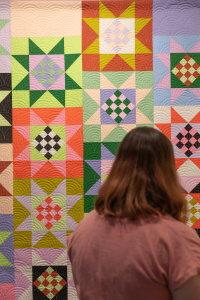 Woman looking at a quilt