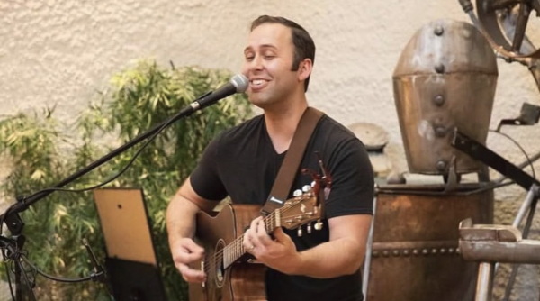 male performer playing guitar in the museum atrium