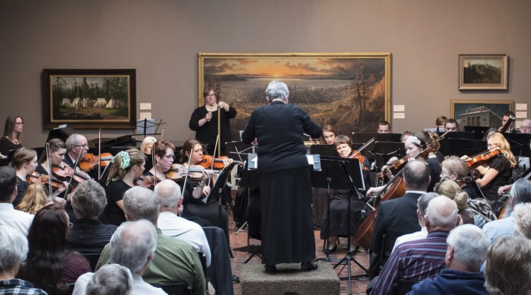 philharmonic group performing for an audience at the museum